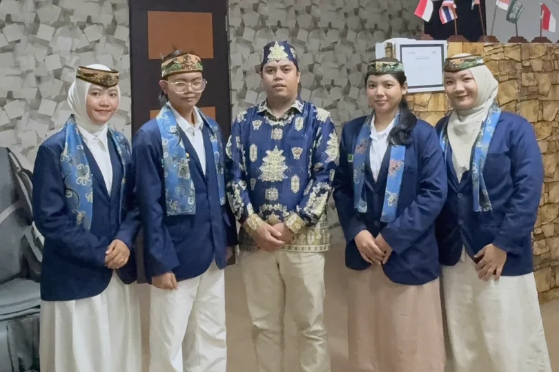 Group documentation in university blazers with traditional headwear.