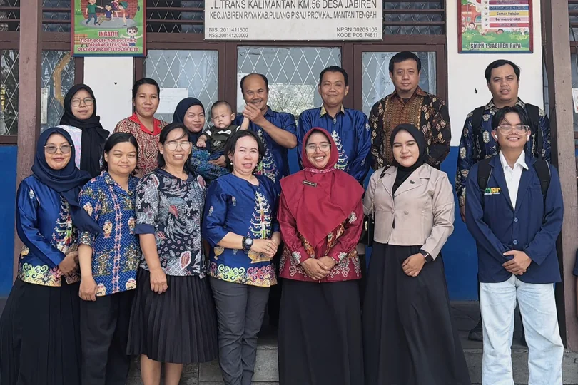 Group photograph in front of the school sign.