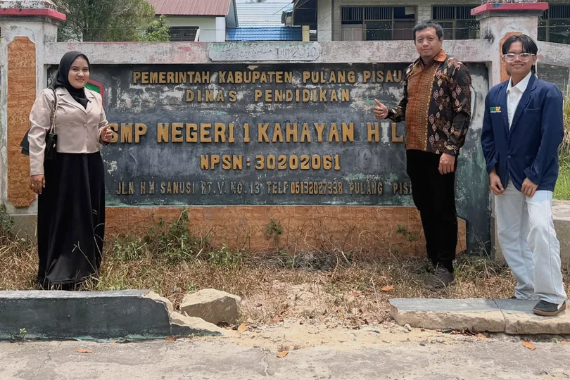 Group photograph beside the school sign.